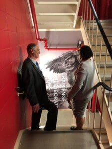 Two people standing and talking on the staircase