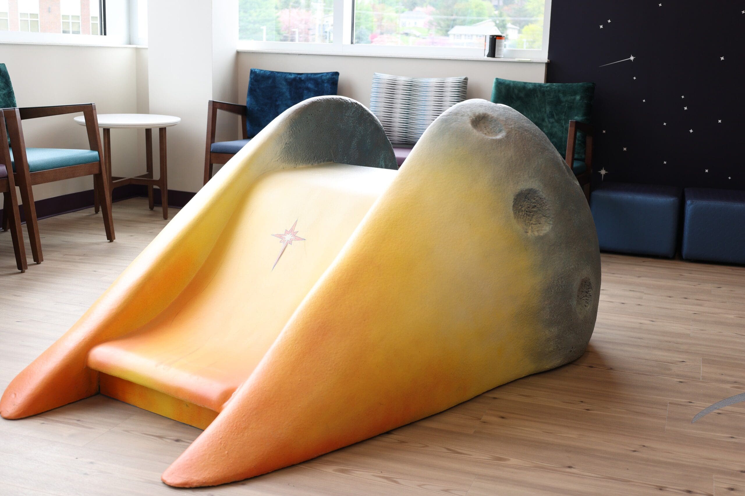 A low slide for children's play area with stary wall decoration
